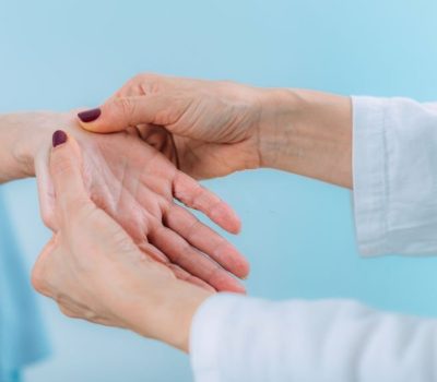 Doctor doing carpal tunnel syndrome test with a senior woman.
