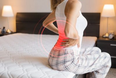 Caucasian ethnicity female suffering from back pain because of uncomfortable mattress