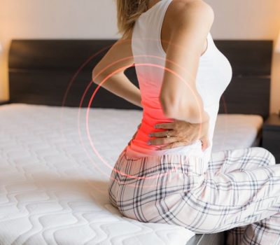 Caucasian ethnicity female suffering from back pain because of uncomfortable mattress