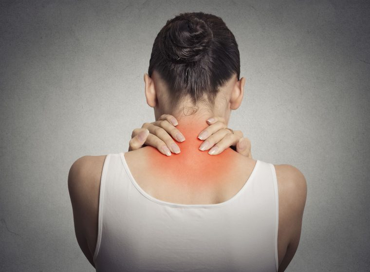 Healthy lifestyle. Back and spine disease. Closeup back view tired female massaging her neck colored in red isolated on gray background